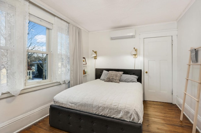 bedroom with dark hardwood / wood-style flooring, ornamental molding, and a wall unit AC