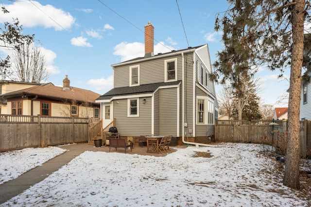 view of snow covered rear of property