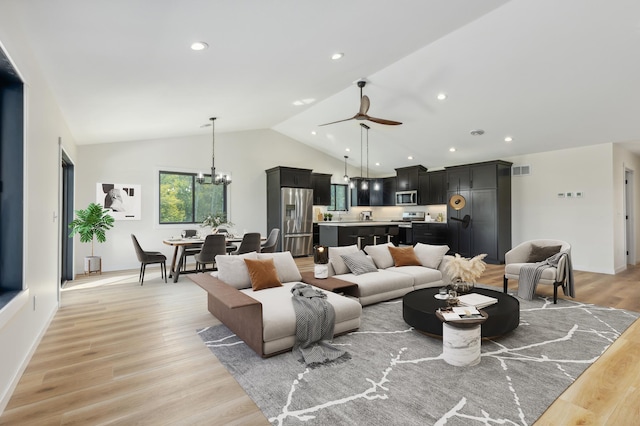 living room featuring ceiling fan with notable chandelier, light hardwood / wood-style flooring, and lofted ceiling