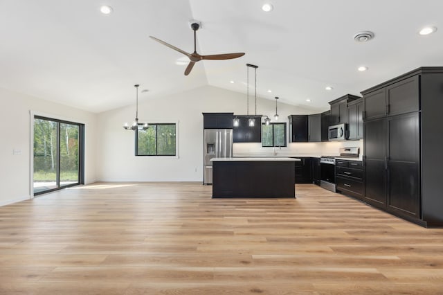 kitchen featuring ceiling fan with notable chandelier, pendant lighting, a center island, stainless steel appliances, and light hardwood / wood-style flooring