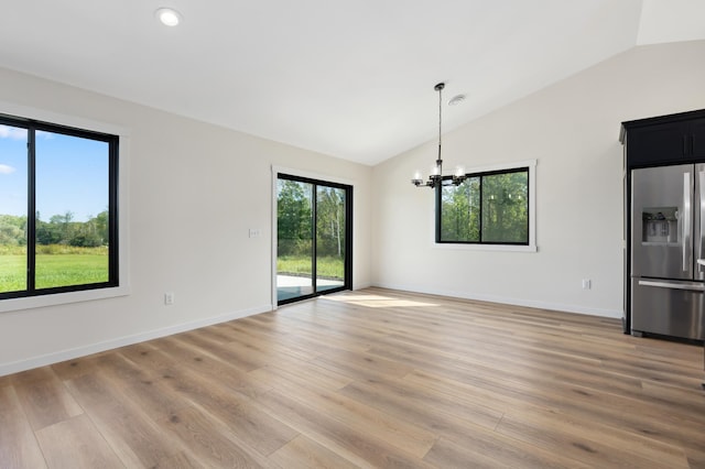 interior space featuring vaulted ceiling, a chandelier, and light hardwood / wood-style floors