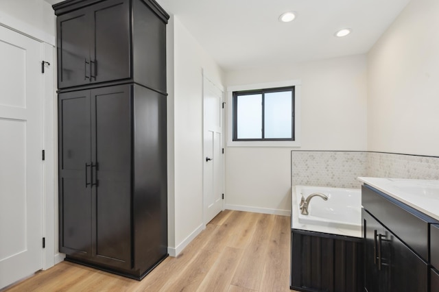 bathroom featuring hardwood / wood-style floors, vanity, and a bathtub