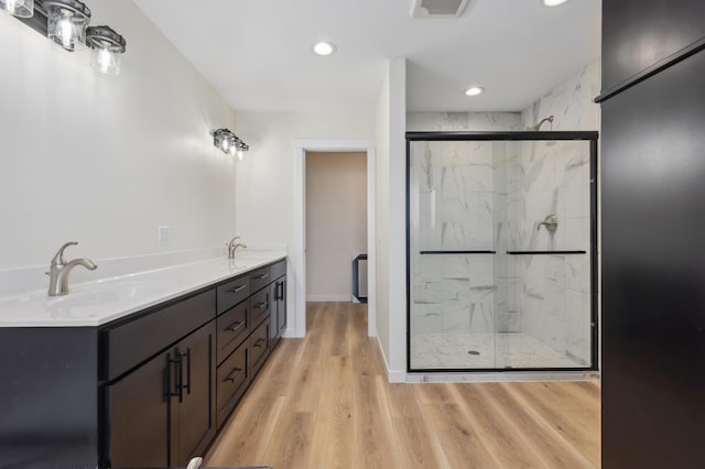 bathroom featuring vanity, a shower with shower door, and wood-type flooring