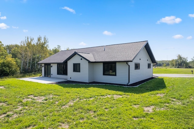 back of house featuring a lawn and a patio