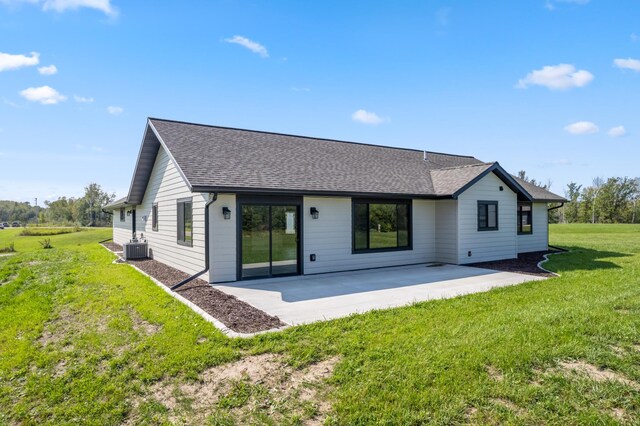 rear view of property with a patio, a lawn, and central AC