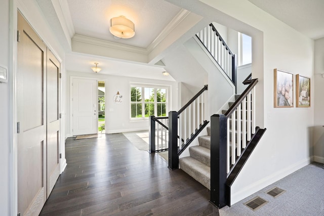 entryway with crown molding, a textured ceiling, and dark hardwood / wood-style floors