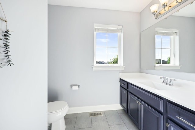 bathroom with toilet, vanity, and an inviting chandelier