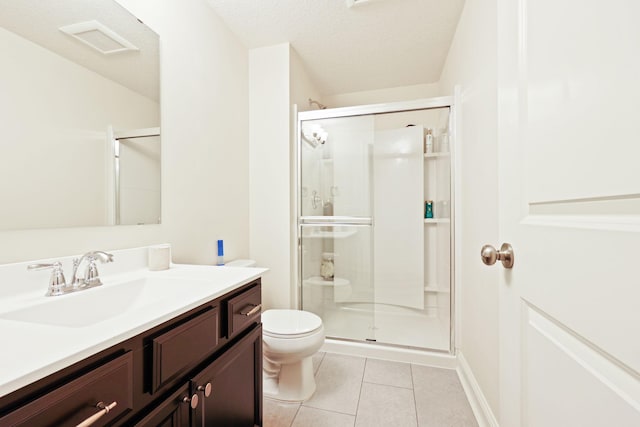 bathroom with a shower with door, tile patterned flooring, a textured ceiling, toilet, and vanity