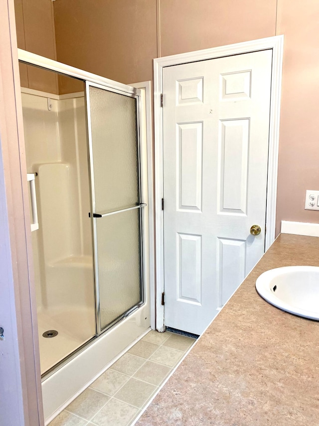 bathroom with tile patterned floors, a shower with shower door, and vanity