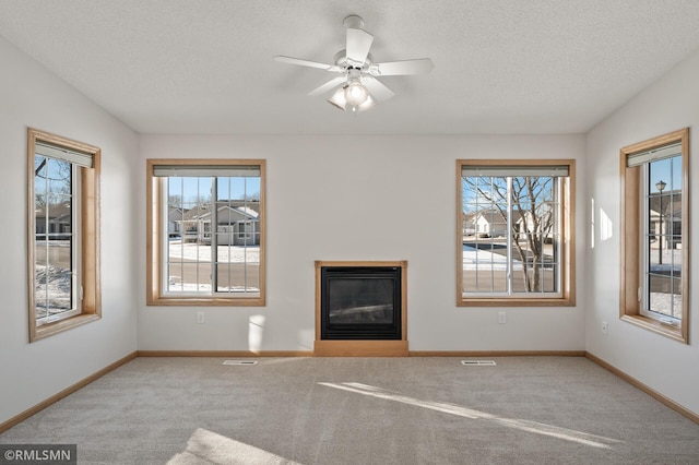 unfurnished living room featuring ceiling fan, carpet, lofted ceiling, and a textured ceiling