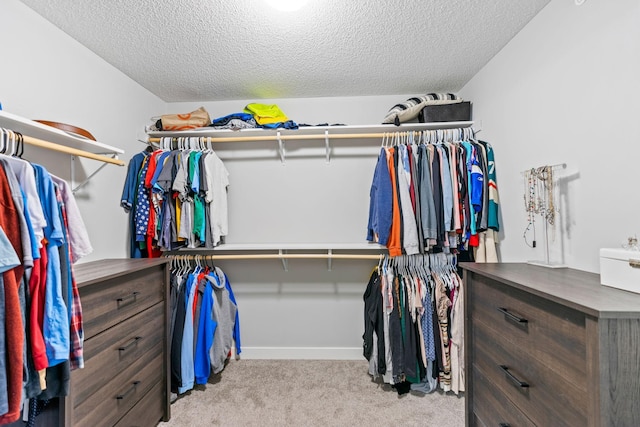 walk in closet featuring light colored carpet