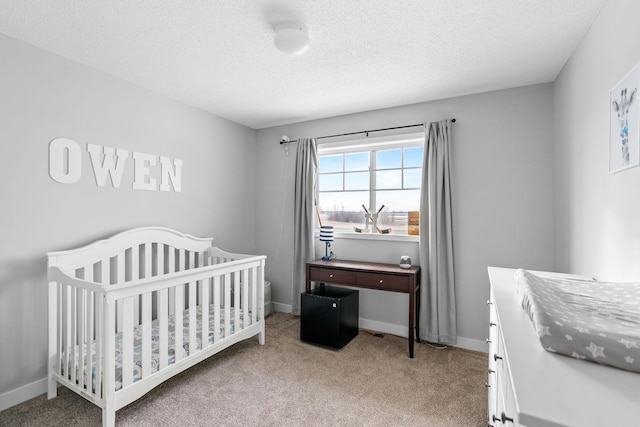 carpeted bedroom featuring a crib and a textured ceiling