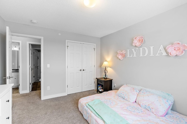 bedroom with light colored carpet, a textured ceiling, and a closet