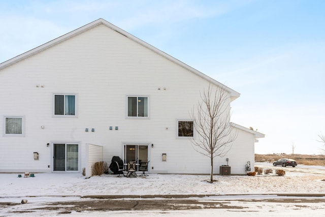 snow covered back of property with cooling unit