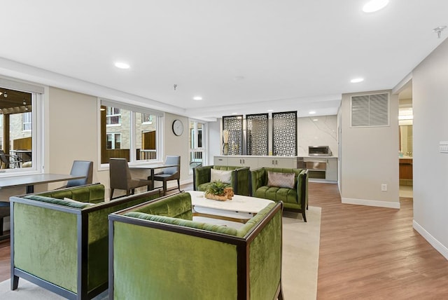 living room featuring a wealth of natural light and light hardwood / wood-style flooring