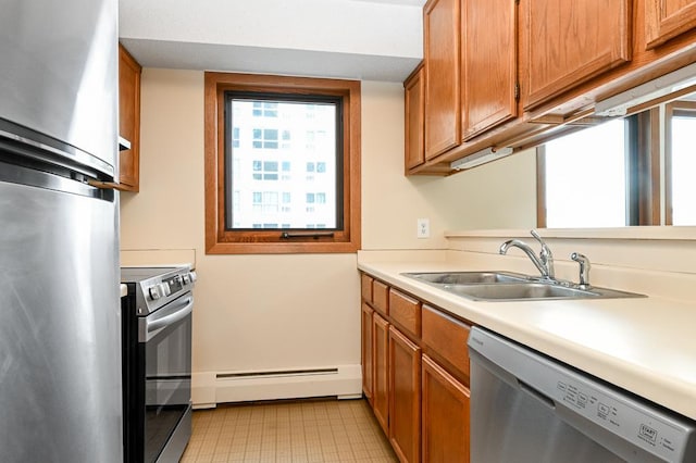 433 7th St Unit 1628, Minneapolis, MN 55415 - kitchen with a baseboard heating unit, appliances with stainless steel finishes, a sink, light countertops, and brown cabinets