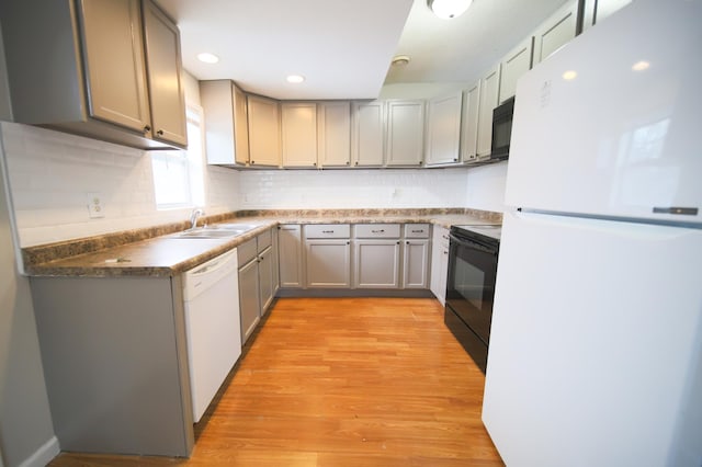 kitchen featuring sink, black appliances, gray cabinetry, and light wood-type flooring