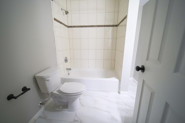 bathroom featuring tiled shower / bath combo and toilet