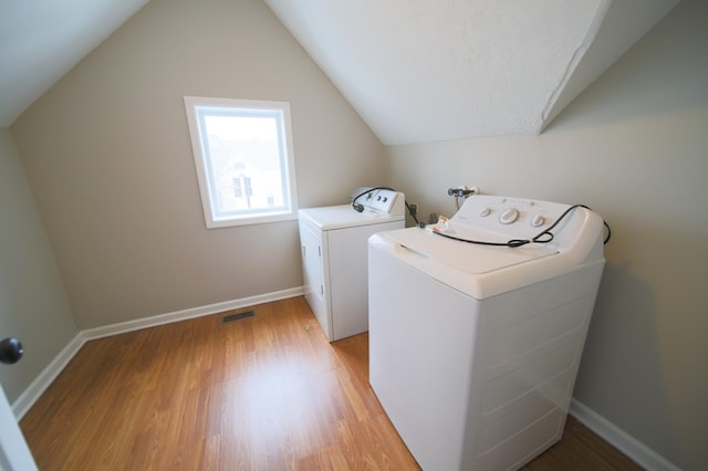 clothes washing area featuring light hardwood / wood-style flooring and independent washer and dryer