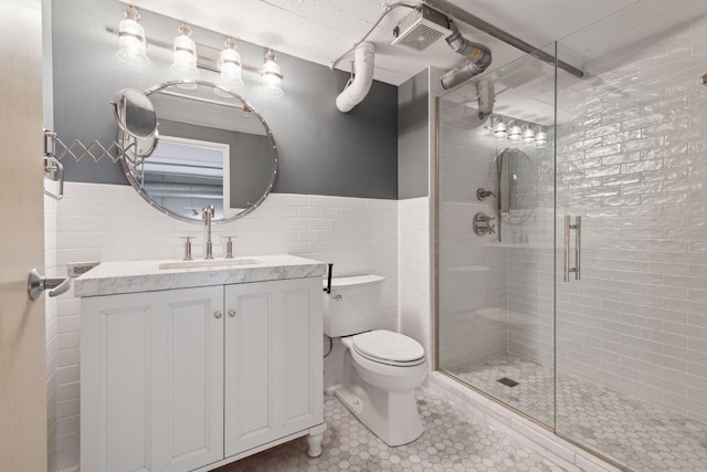 bathroom featuring tile walls, tile patterned flooring, vanity, toilet, and walk in shower