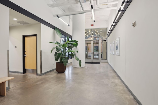 hall with a towering ceiling and concrete floors