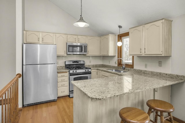 kitchen featuring decorative light fixtures, stainless steel appliances, decorative backsplash, sink, and vaulted ceiling