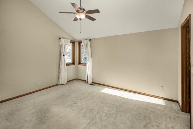 empty room with ceiling fan, light colored carpet, and lofted ceiling