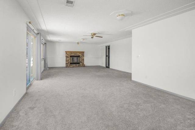 unfurnished living room featuring light carpet, ceiling fan, ornamental molding, and a fireplace