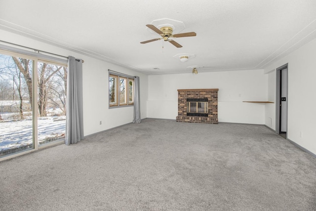 unfurnished living room with a fireplace, carpet flooring, ceiling fan, and crown molding