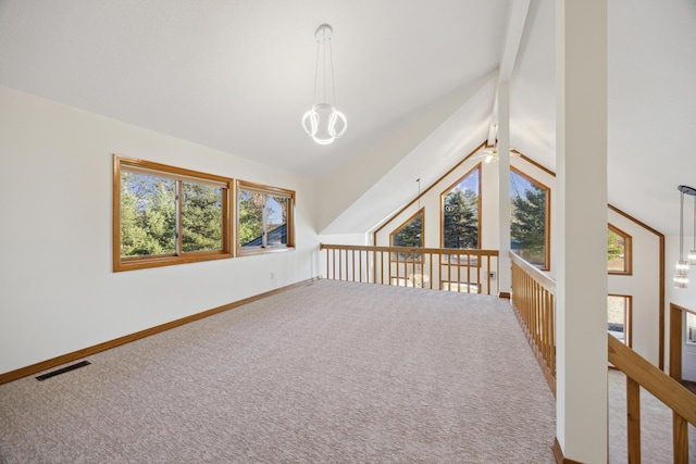 additional living space featuring lofted ceiling with beams, carpet flooring, and ceiling fan with notable chandelier