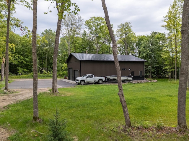 view of outdoor structure featuring a garage and a lawn