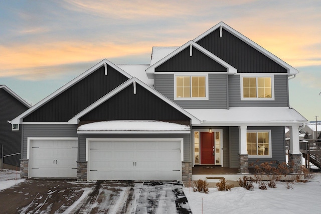 craftsman-style home with a garage, stone siding, covered porch, and board and batten siding