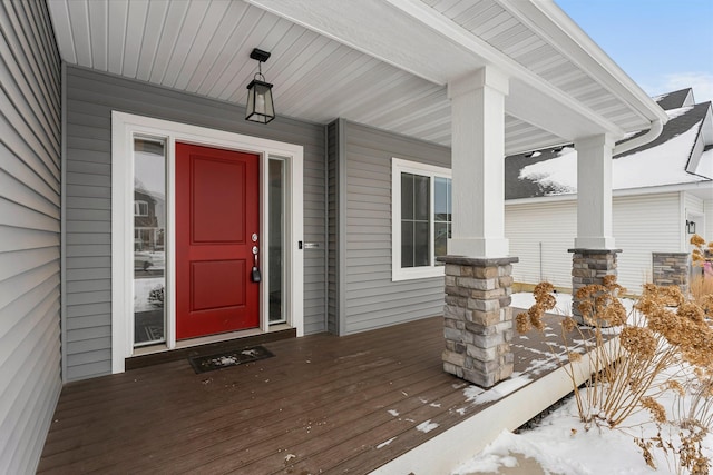 snow covered property entrance featuring a porch