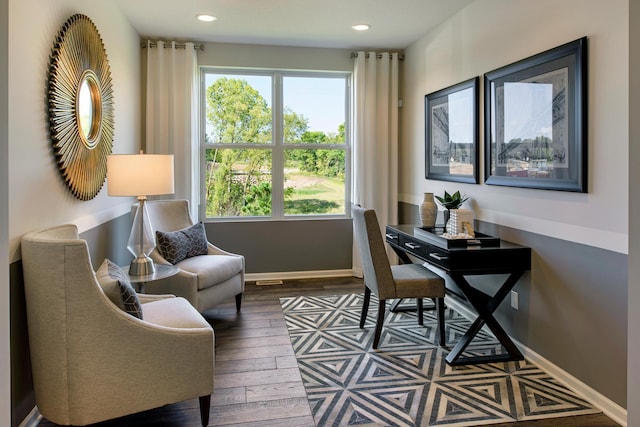 living area featuring plenty of natural light and dark hardwood / wood-style floors