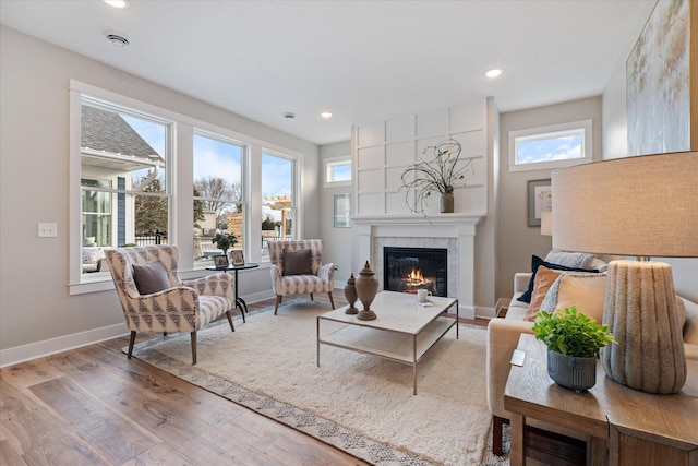 living room with light wood-type flooring and a large fireplace