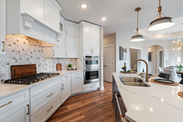 kitchen featuring sink, backsplash, white cabinetry, and stainless steel appliances