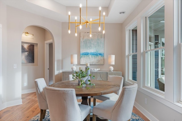 dining area featuring light wood-type flooring and a notable chandelier