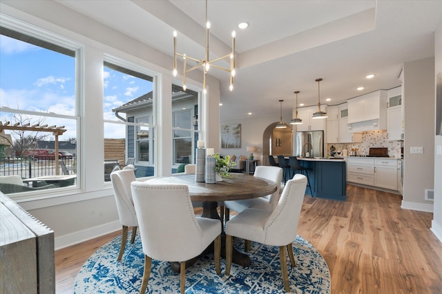 dining room featuring light hardwood / wood-style floors and a tray ceiling