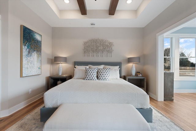 bedroom featuring hardwood / wood-style floors and beamed ceiling