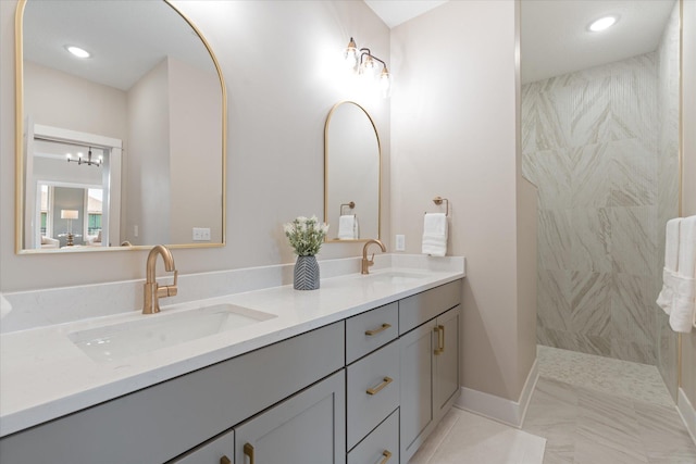 bathroom featuring tiled shower and vanity