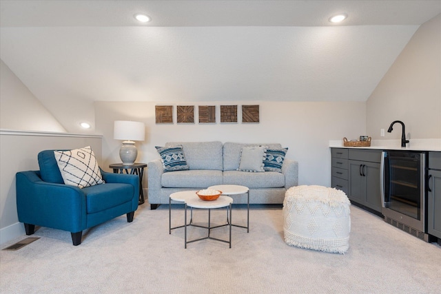 living room with wet bar, vaulted ceiling, light carpet, and wine cooler