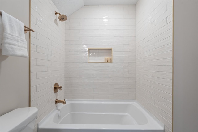 bathroom featuring toilet, a textured ceiling, and shower / bathing tub combination