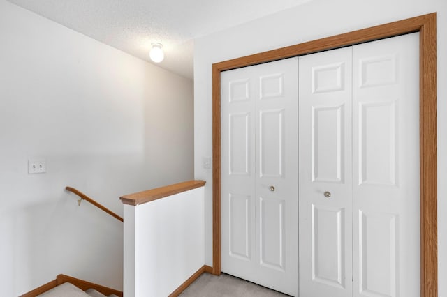 interior space featuring a textured ceiling and light colored carpet