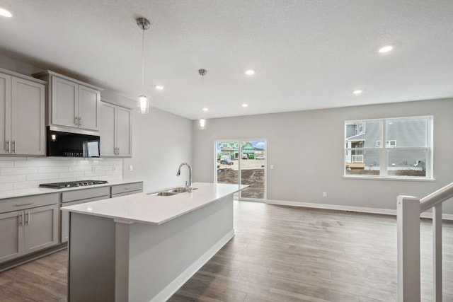 13617 Aulden Ave, Rosemount, MN 55068 - kitchen with a sink, backsplash, stainless steel gas stovetop, wood finished floors, and gray cabinets