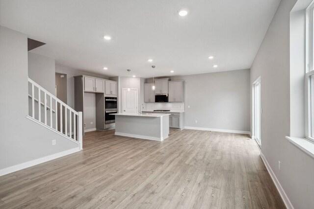 13617 Aulden Ave, Rosemount, MN 55068 - unfurnished living room featuring recessed lighting, stairway, baseboards, and light wood-style flooring
