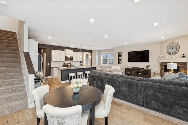 dining space with a fireplace and light hardwood / wood-style floors