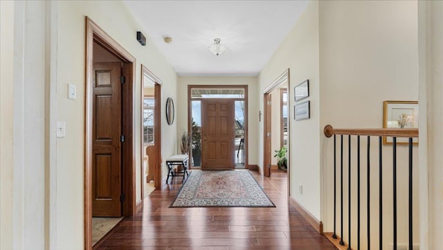 foyer entrance featuring dark wood finished floors and baseboards