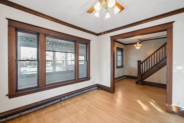 spare room with a baseboard radiator, ornamental molding, light hardwood / wood-style flooring, and a wealth of natural light