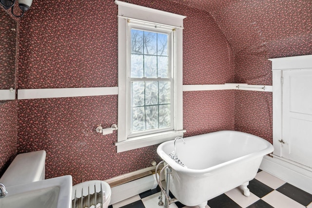 bathroom featuring toilet, a bathtub, and a wealth of natural light