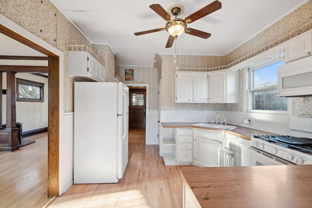 kitchen featuring white cabinetry, white appliances, sink, and light hardwood / wood-style flooring